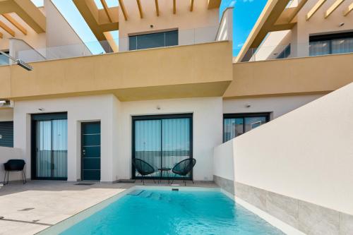 a house with a swimming pool in front of it at Rojales Golf House - by Welcomely in Rojales