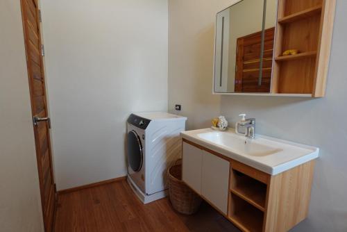 a bathroom with a washing machine and a sink at Yume17 in Chaloklum