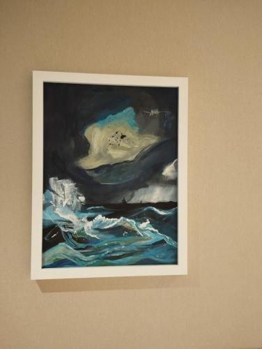 a painting of the ocean on a wall at Sileo Apart No.85 in Ustka