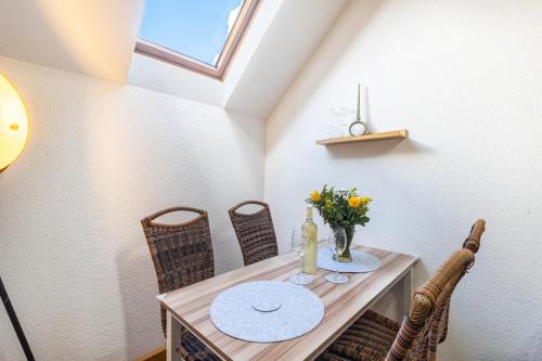 a dining room table with chairs and a vase of flowers at Ferienwohnung Beti in Korbach