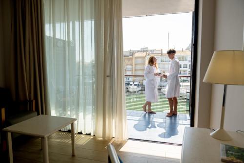 two women standing on the balcony of a hotel room at Hotel Port Salins by Pierre & Vacances in Empuriabrava
