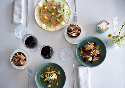 a white table with plates of food and glasses of wine at Hotel Port Salins by Pierre & Vacances in Empuriabrava