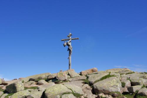 a crucifix on top of a pile of rocks at SAN PIETRO DOLOMITI Small Budget Hotel in Ortisei