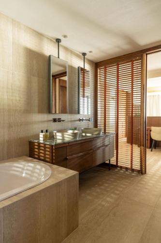a bathroom with a tub and a sink and a mirror at Legend Hill Resort and Spa in Rivière Noire
