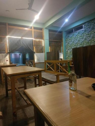 Un comedor con mesas de madera en una habitación. en Shree Muktinath Hotel, en Pokhara