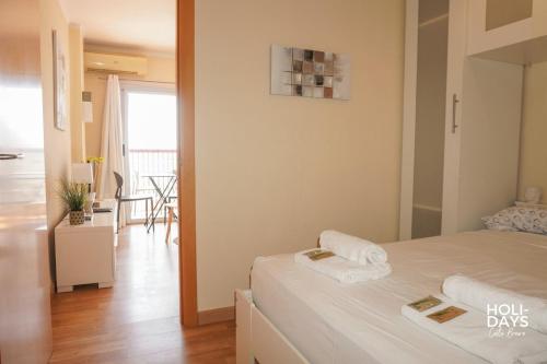 エンプリアブラバにあるHolidays Sol y Mar, beachfrontのベッドとタオル2枚のある寝室