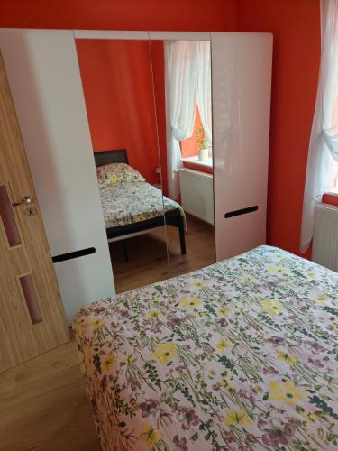 a small bedroom with a bed and a mirror at Pensjonat Jak w Domu in Ostróda