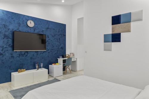a bedroom with a tv on a blue wall at Selari Boutique in Bucharest