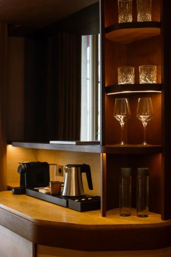 a kitchen counter with a coffee maker and wine glasses at Hôtel Confidentiel - Louvre in Paris