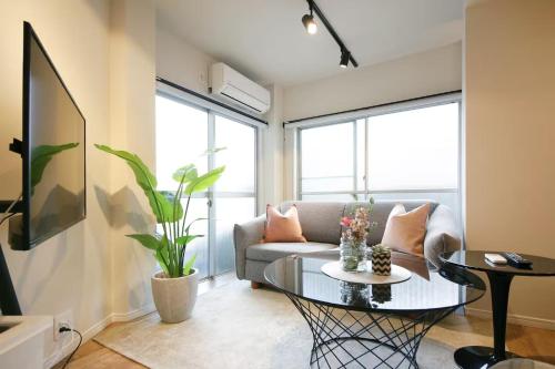 a living room with a couch and a table at 9STAY Shibuya Shinsen in Tokyo
