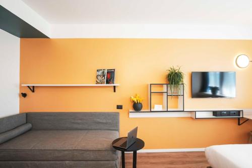 a living room with a couch and a tv on a wall at Aparthotel Colombo Roma in Rome