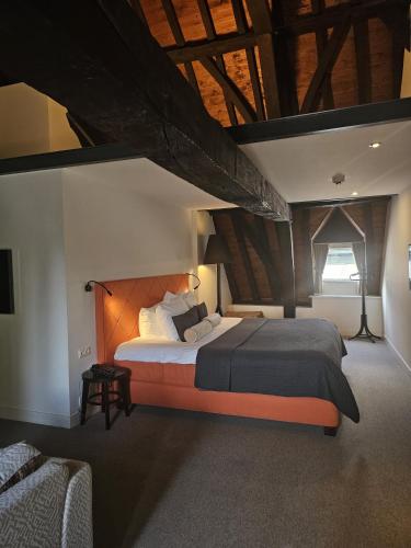 una camera da letto con un letto grande in una stanza con soffitti in legno di Hampshire Hotel - 's Gravenhof Zutphen a Zutphen