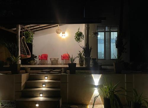 une pièce avec des plantes en pot et des chaises rouges la nuit dans l'établissement Mount Lavender Weligama, à Weligama