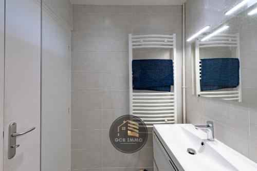 a white bathroom with a sink and a mirror at Lesdiguieres 3 Bedrooms Parking in Grenoble