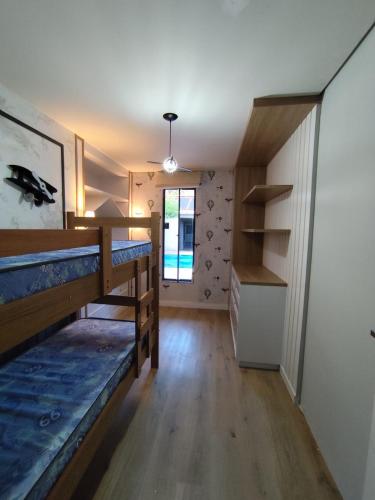 a room with two bunk beds and a hallway at Casa de 3 quartos com piscina in Laranjeiras do Sul