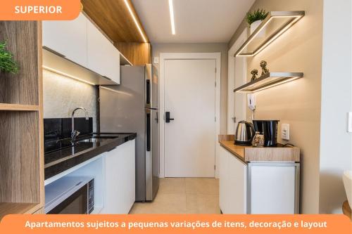 a kitchen with white cabinets and a sink at GO Carlos Gomes by My Way in Porto Alegre