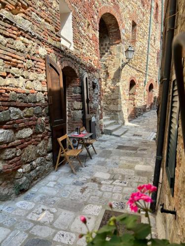 an alley in an old stone building with a table at Casa Betta - A 700 Year Old Tuscan Gem in Chiusdino