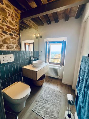 a bathroom with a toilet and a sink and a window at Casa Betta - A 700 Year Old Tuscan Gem in Chiusdino