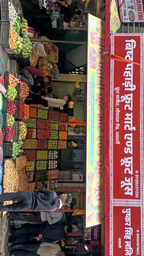 a person standing in front of a display of fruit at Nainital heaven in Bhowāli