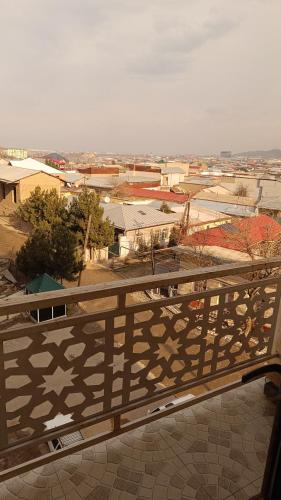 a wooden bench sitting on a balcony overlooking a city at Квартира Комфорт in Samarkand