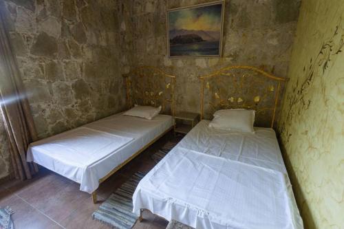 two beds in a corner of a room at Casa Paradise in Dilijan