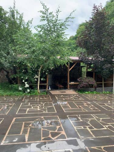a stone courtyard with a tree and a pavilion at Casa Paradise in Dilijan