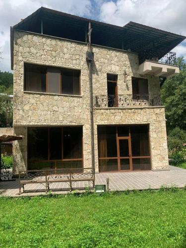 a stone house with a balcony on top of it at Casa Paradise in Dilijan