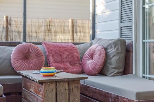 a couch with pillows and a table on a porch at chalet in Putten