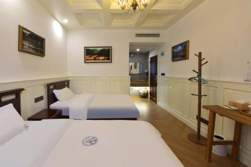 a room with two beds and a cross on the wall at Dream in Fenghuang in Fenghuang