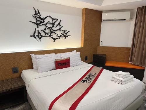 a hotel room with a large bed with a sign on it at Dragon River Avenue in Phitsanulok