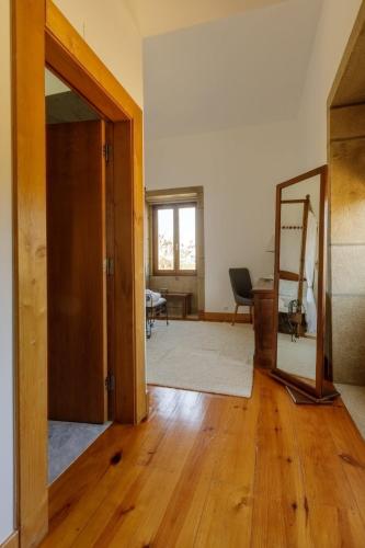 an empty room with a door and a mirror at Hotel Rural Casa de Samaioes in Chaves