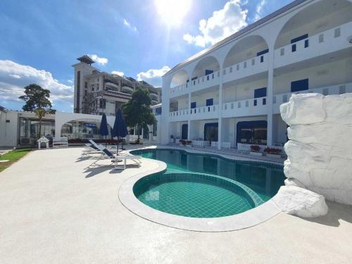 a hotel with a swimming pool in front of a building at To The Sea by Belvilla in Na Jomtien