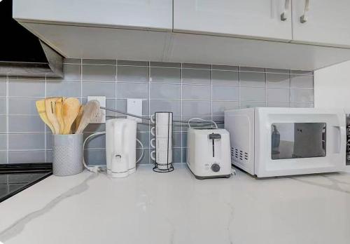 a kitchen counter with a microwave and utensils at Downsview Park Townhome queen bed near Yorkdale Transit in Toronto