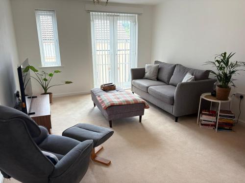 a living room with two couches and a table at Modern, Spotless Flat Near M4,Free Parking & Wi-Fi in Pontardulais