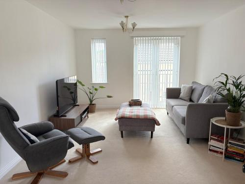 a living room with a couch and a tv at Modern, Spotless Flat Near M4,Free Parking & Wi-Fi in Pontardulais