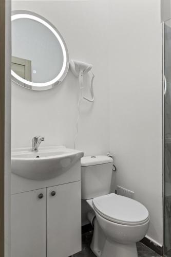 a bathroom with a toilet and a sink and a mirror at Selari Boutique in Bucharest
