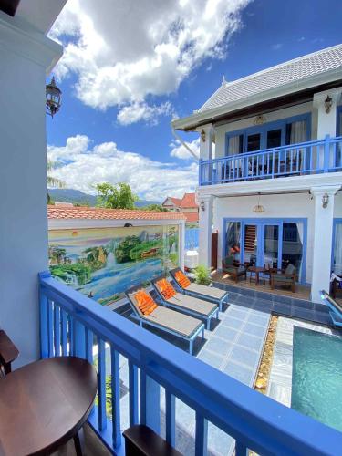a balcony with a swimming pool and a house at Sadakham Royal View Hotel in Luang Prabang