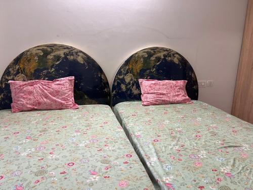 two beds with pillows sitting next to each other at MountainNest Wrapped in Clouds in Dehradun