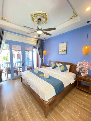 a bedroom with a large bed with a blue wall at Sadakham Royal View Hotel in Luang Prabang