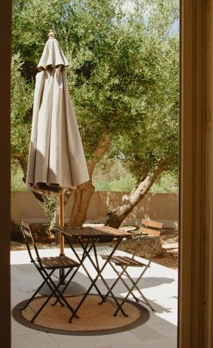 a table with an umbrella and a chair and a table with an umbrella at Villa Gufo in Ostuni