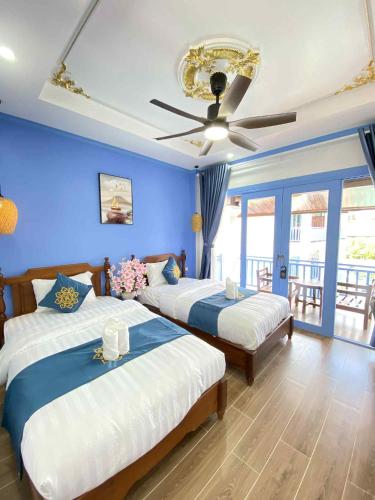 a bedroom with two beds and a ceiling fan at Sadakham Royal View Hotel in Luang Prabang