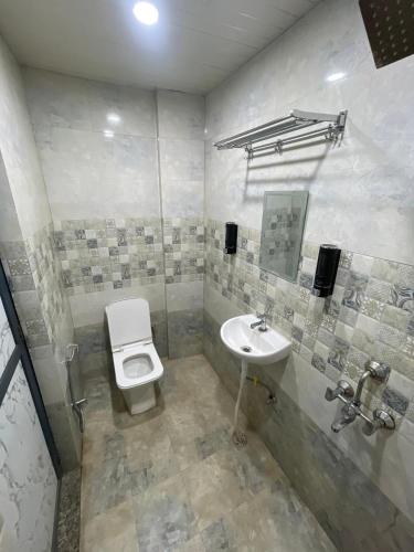 a bathroom with a toilet and a sink at Hotel ShivKashi Inn in Varanasi