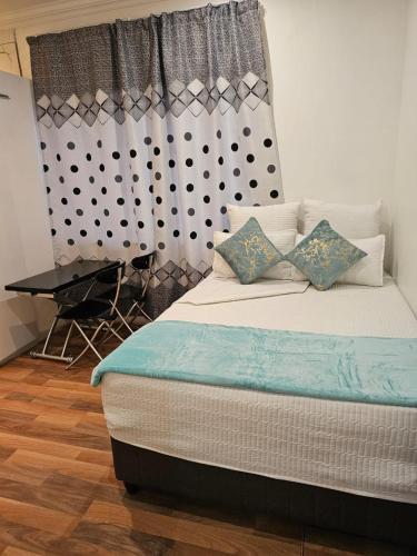a bedroom with a bed and a table and a window at WiseStar Guest House in Johannesburg