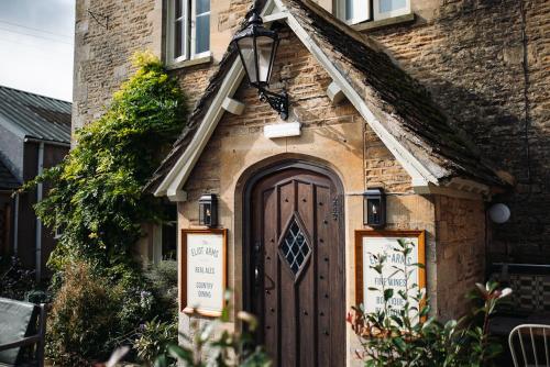 a brick house with a wooden door in front of it at Eliot Arms in Cirencester