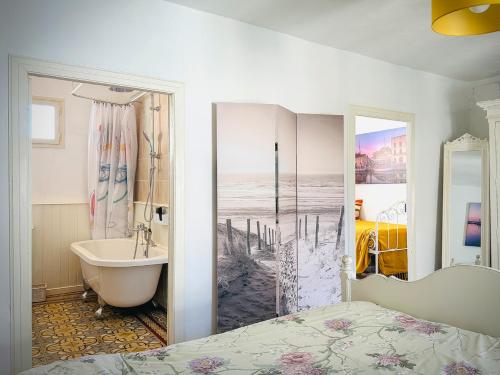 ein Schlafzimmer mit Bett, Badewanne und Waschbecken in der Unterkunft La Petite Maison in Marseillan