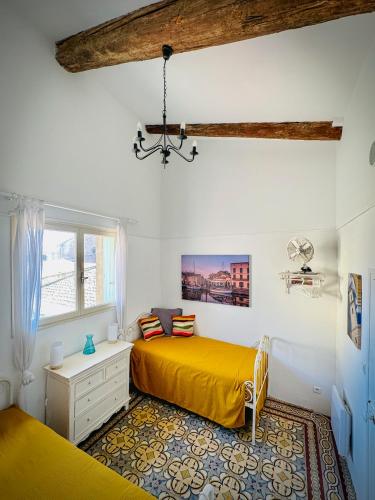 ein Schlafzimmer mit einem gelben Bett und einem Fenster in der Unterkunft La Petite Maison in Marseillan