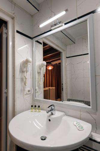 a bathroom with a sink and a large mirror at Hotel Aria center in Tirana