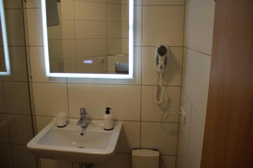 a bathroom with a sink and a mirror at Großzügiges Erdgeschoßapartment mit Balkon und eigenen kostenlosen Parkplatz in Hövelhof
