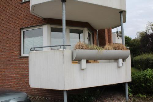 a house with a planter on the side of it at Großzügiges Erdgeschoßapartment mit Balkon und eigenen kostenlosen Parkplatz in Hövelhof