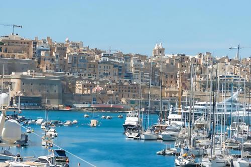 a group of boats docked in a harbor with buildings at Medieval Knights house GF with Seaview at the Three Cities Marina in Senglea